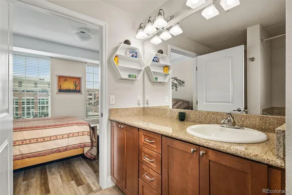 a en suite bathroom with a granite countertop double vanity sink and a mirror
