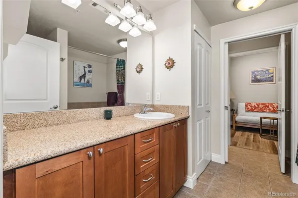a bathroom with a granite countertop sink a large mirror and a shower