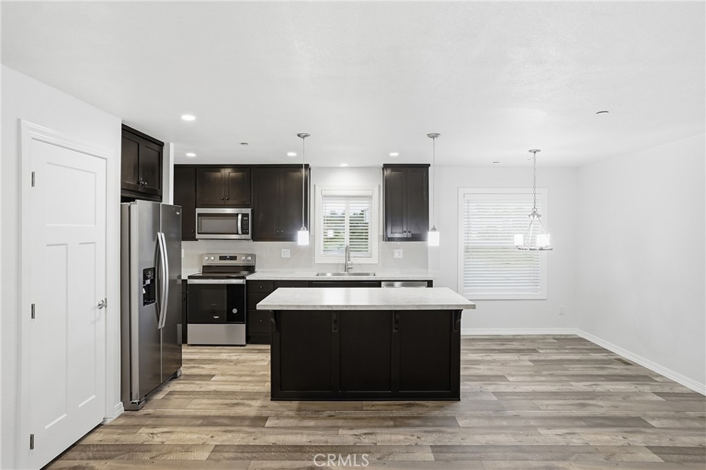 4237 Del Rosa Road Phelan, CA 92371 - Photo 16 of 37 a large kitchen with stainless steel appliances a sink and cabinets