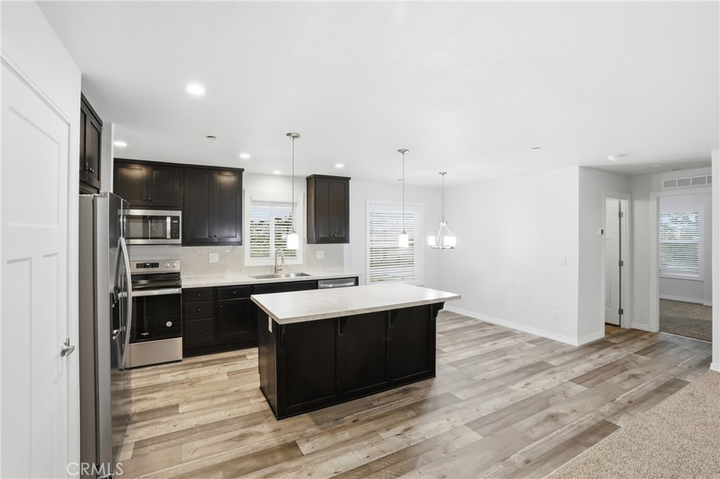 4237 Del Rosa Road Phelan, CA 92371 - Photo 2 of 37 a kitchen with stainless steel appliances kitchen island granite countertop a sink refrigerator and cabinets