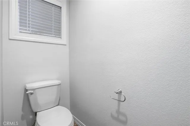 a white toilet sitting next to a window
