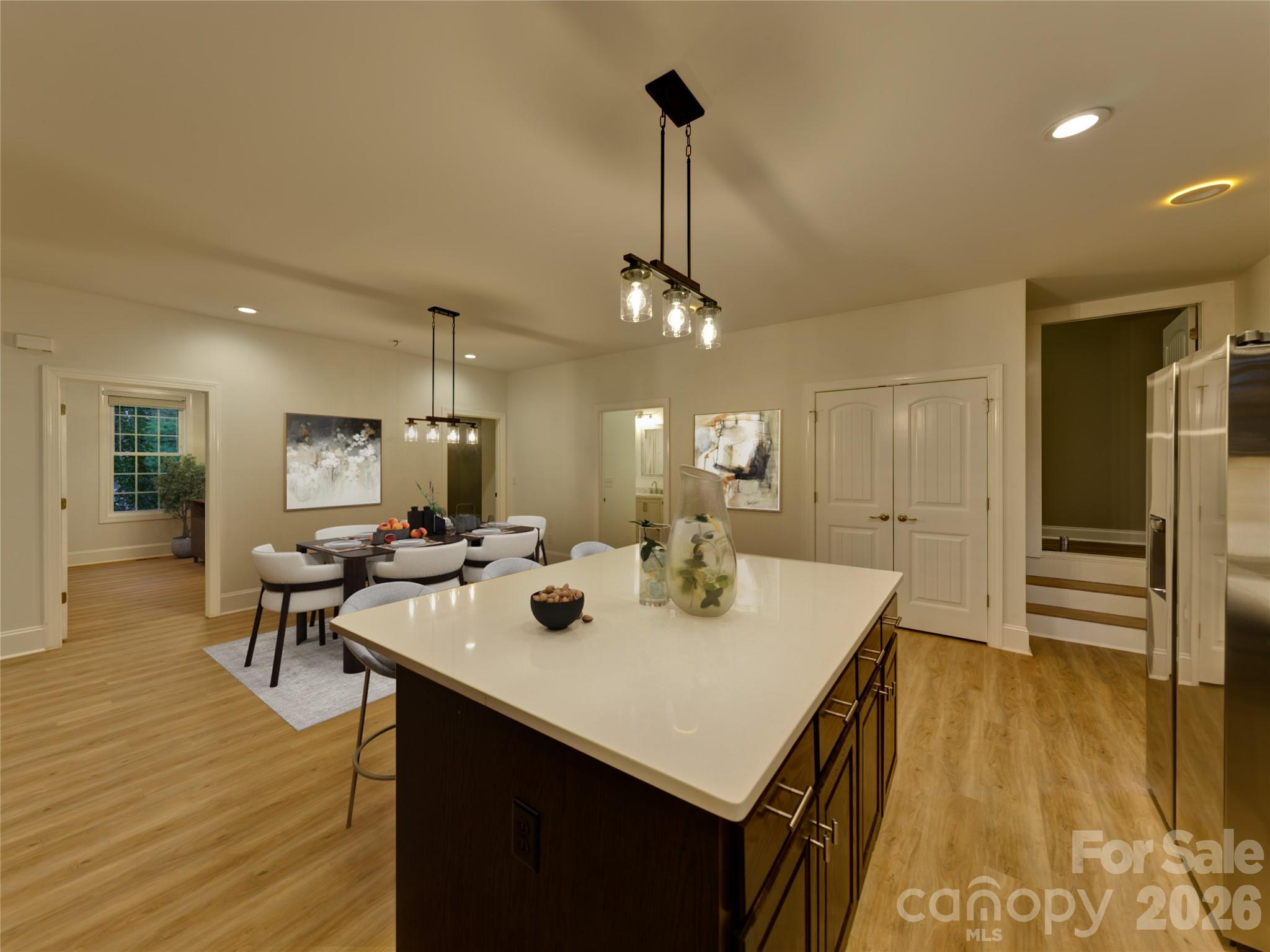 206 Montclair Drive Locust, NC 28097 - Photo 13 of 40 a view of a dining room and livingroom with furniture wooden floor a rug a flat screen tv a painting and a chandelier