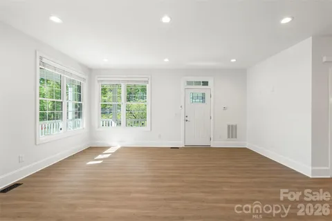 a view of a room with wooden floor and a ceiling fan