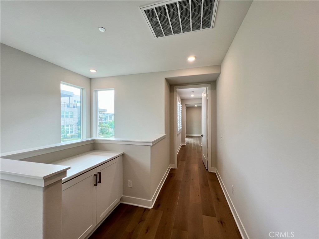 108 Chorus Irvine, CA 92618 - Photo 14 of 39 a view of a hallway with a sink and wooden floor