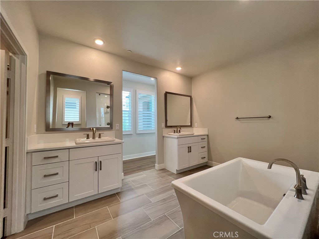 108 Chorus Irvine, CA 92618 - Photo 15 of 39 a large bathroom with a tub sink and mirror