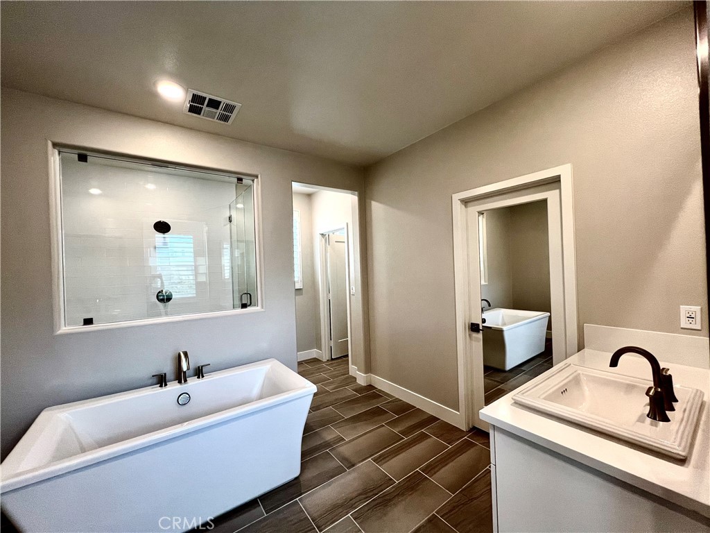 108 Chorus Irvine, CA 92618 - Photo 19 of 39 a bathroom with a bathtub sink mirror and vanity