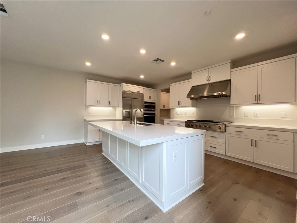 108 Chorus Irvine, CA 92618 - Photo 5 of 39 a kitchen with stainless steel appliances granite countertop a white stove top oven and white cabinets