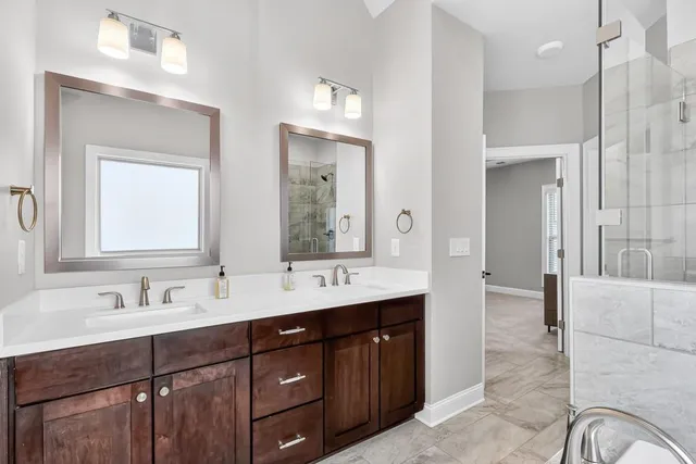 a bathroom with a double vanity sink a mirror and a shower