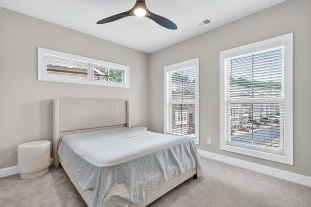 a bedroom with a bed and a large window