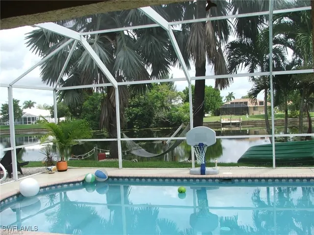 a view of a chair and tables in the patio next to a yard