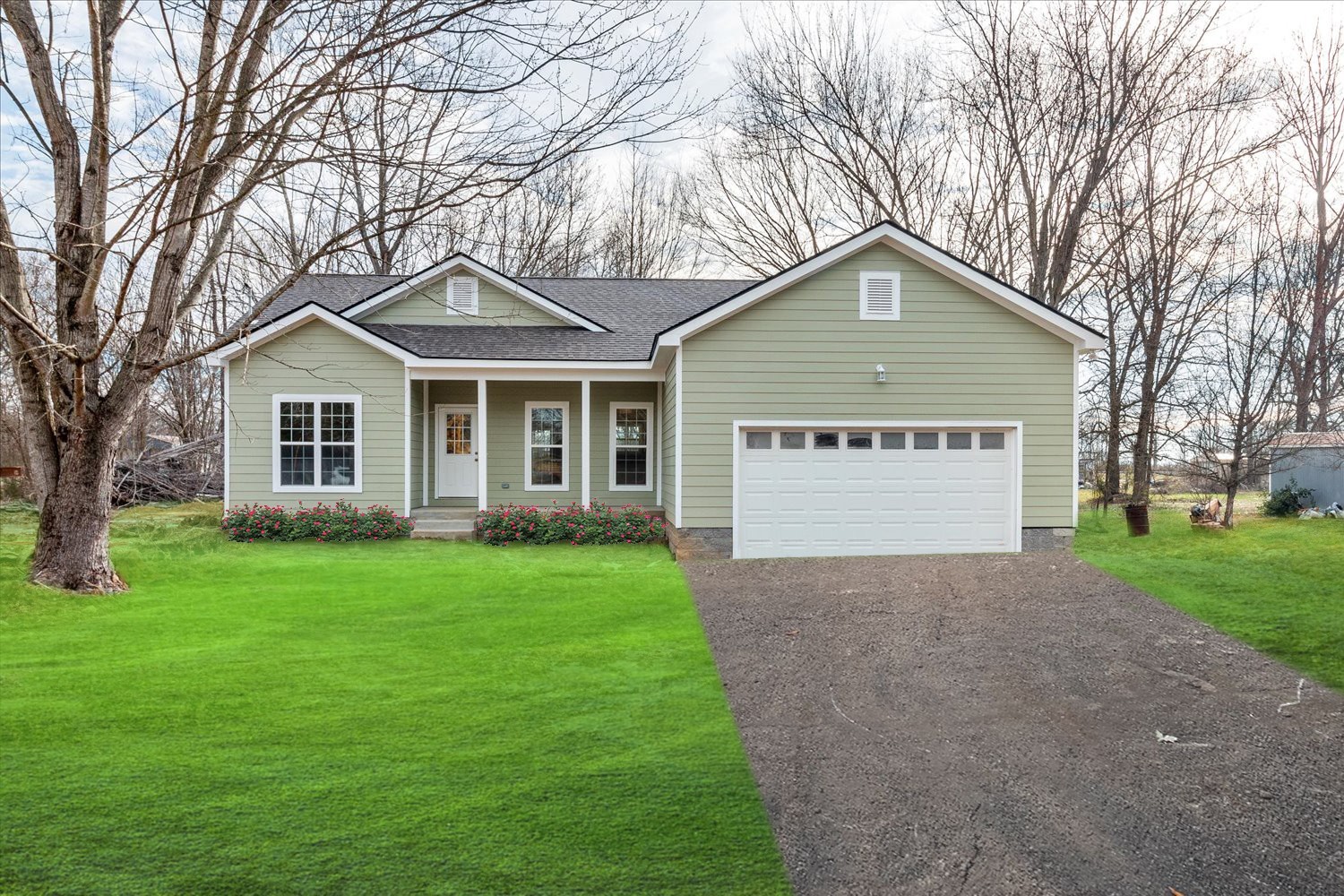 a view of a house with a yard and large trees
