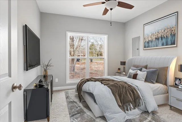 a bedroom with bed tv and window