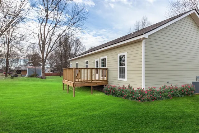 a backyard of a house with potted plants and large tree