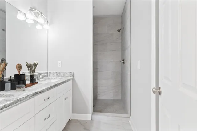 a bathroom with a granite countertop sink a mirror and a shower