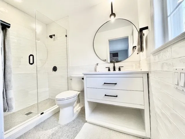 a bathroom with a sink vanity mirror and toilet