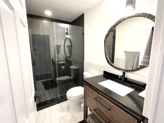 a bathroom with a sink a toilet and a mirror