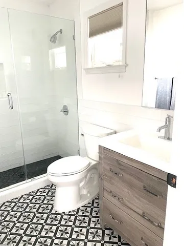 a bathroom with a sink a toilet and a window