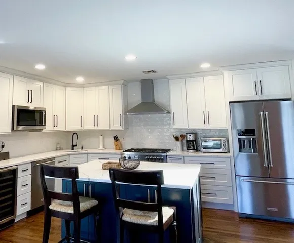 a kitchen with a dining table chairs refrigerator and cabinets