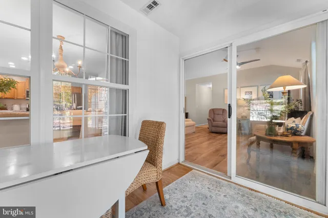 a view of a living room and a dining room with wooden floor