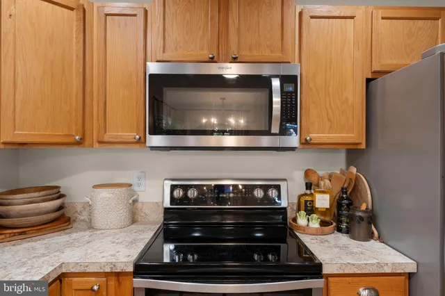 a kitchen with granite countertop wood cabinets and a stove top oven