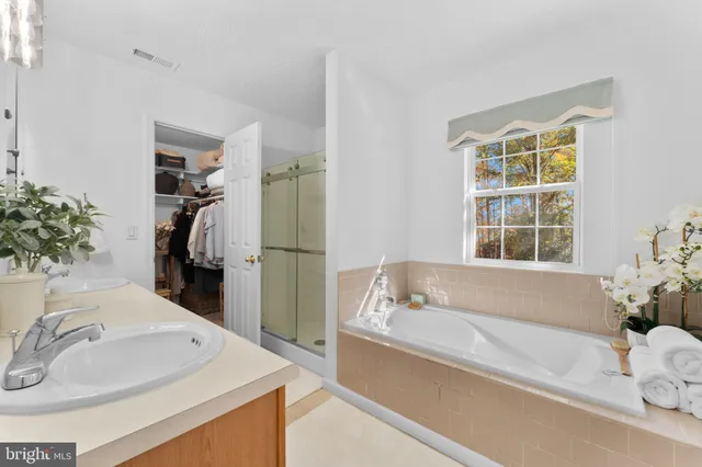 a bathroom with a tub sink and a window