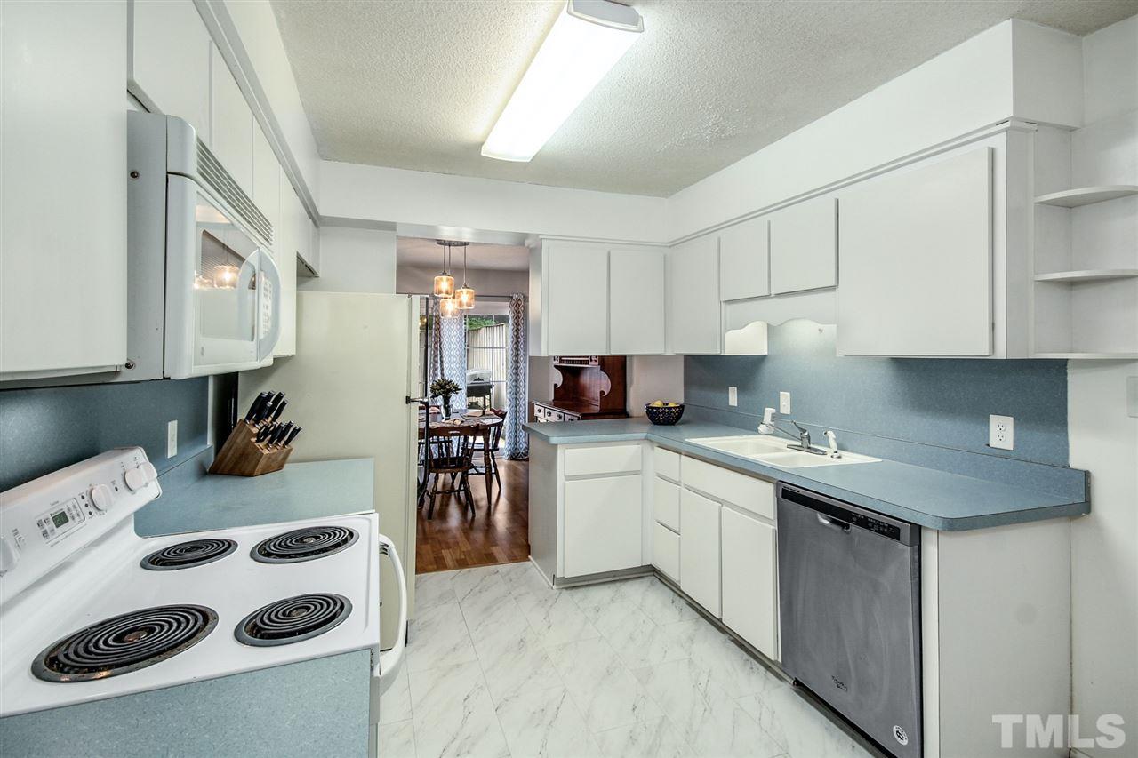 5863 Branchwood Road Raleigh, NC 27609 - Photo 13 of 30 a kitchen with a sink a stove and cabinets