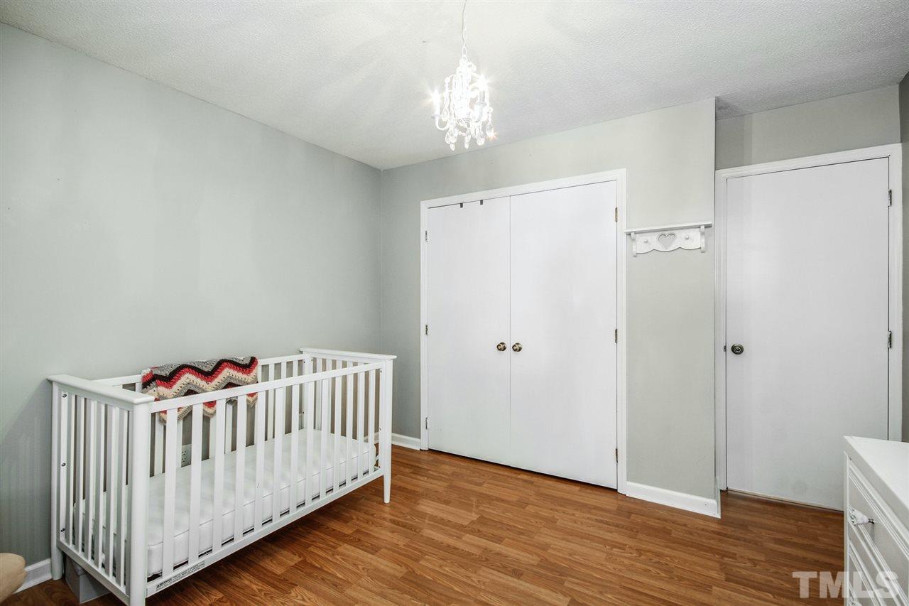 5863 Branchwood Road Raleigh, NC 27609 - Photo 22 of 30 a bedroom with white furniture and wooden floor