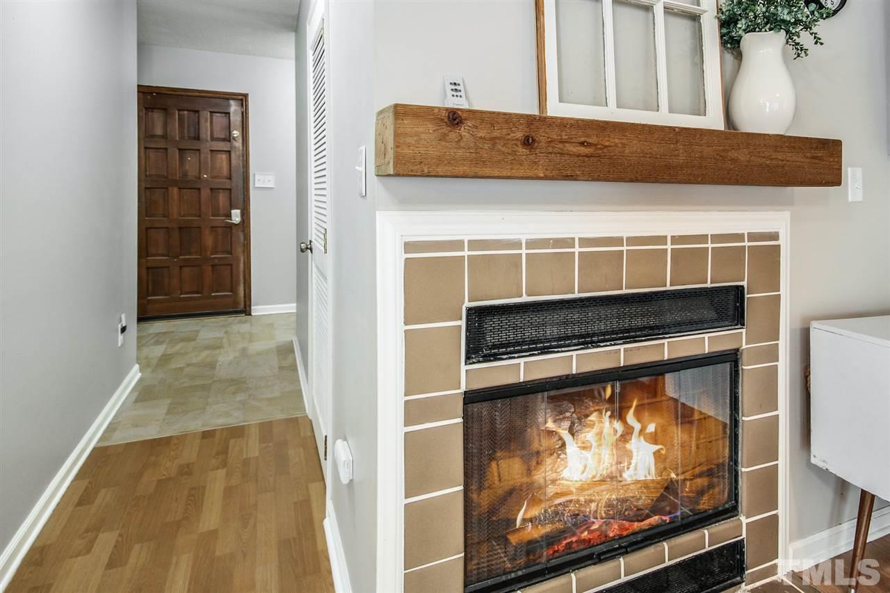 5863 Branchwood Road Raleigh, NC 27609 - Photo 8 of 30 a living room with a fireplace and a flat screen tv