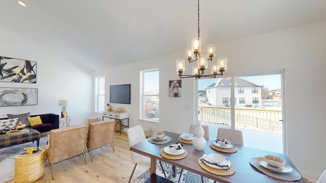 a view of a dining room with furniture a chandelier and wooden floor