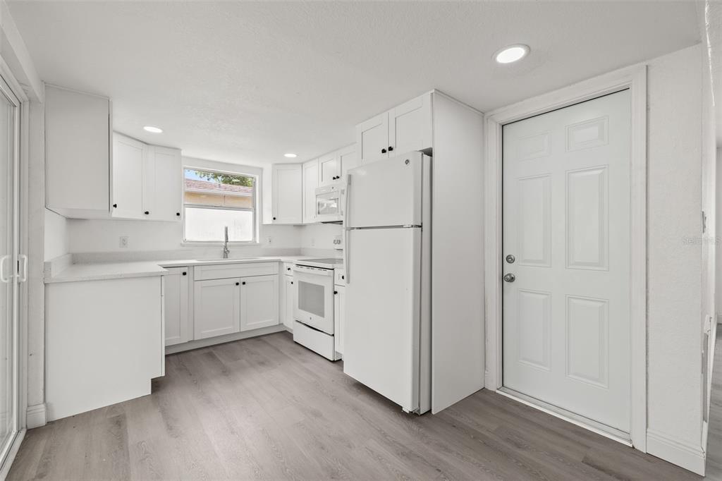 8046 Norwich Drive Port Richey, FL 34668 - Photo 11 of 31 a kitchen with white cabinets and white appliances