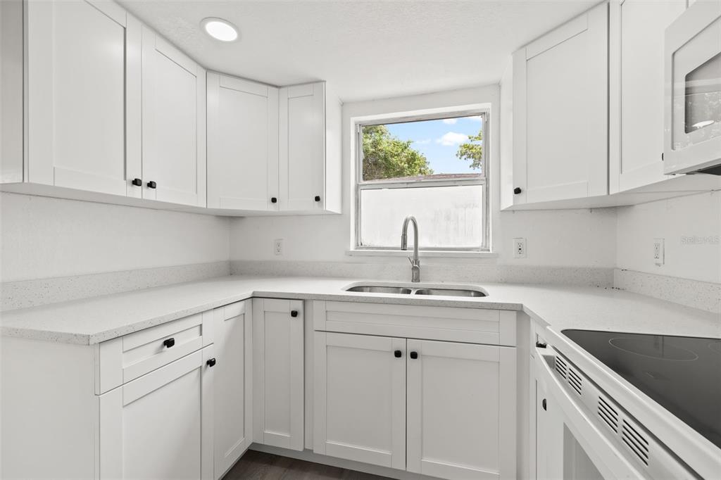 8046 Norwich Drive Port Richey, FL 34668 - Photo 13 of 31 a kitchen with white cabinets and white appliances