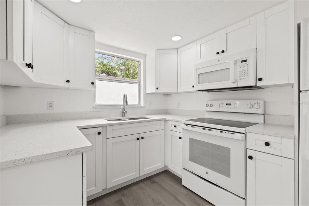 8046 Norwich Drive Port Richey, FL 34668 - Photo 14 of 31 a kitchen with cabinets appliances a sink and a window