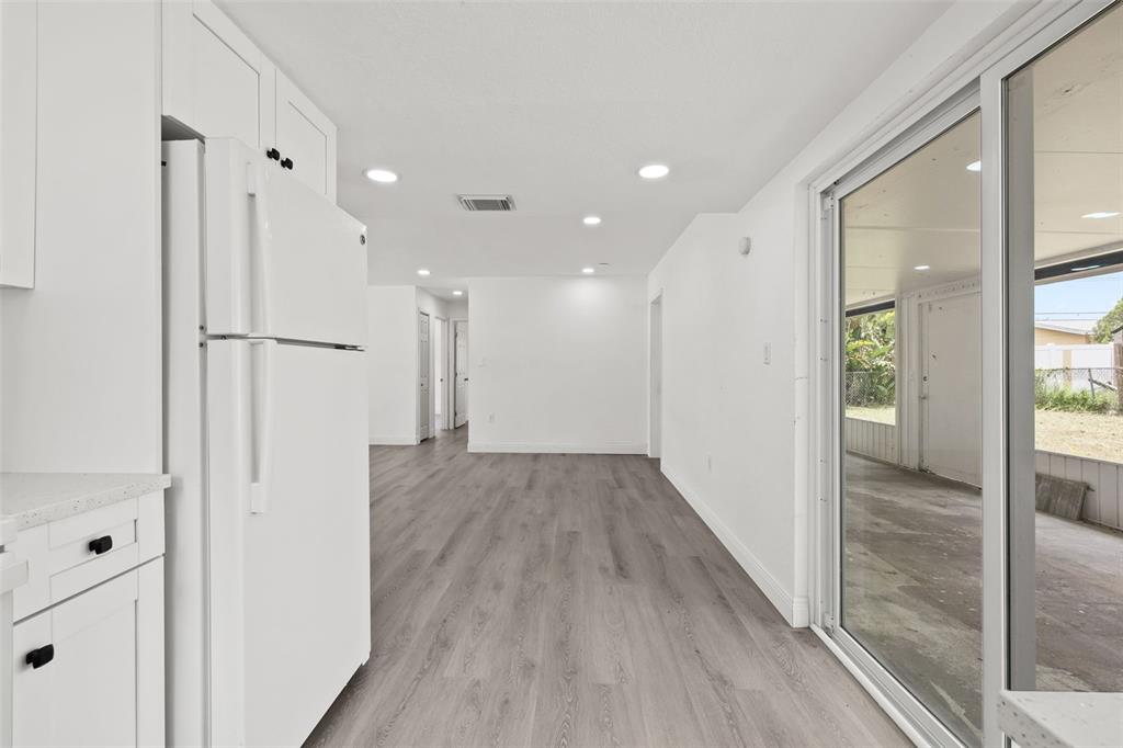 8046 Norwich Drive Port Richey, FL 34668 - Photo 16 of 31 a view of a hallway with wooden floor and a bathroom