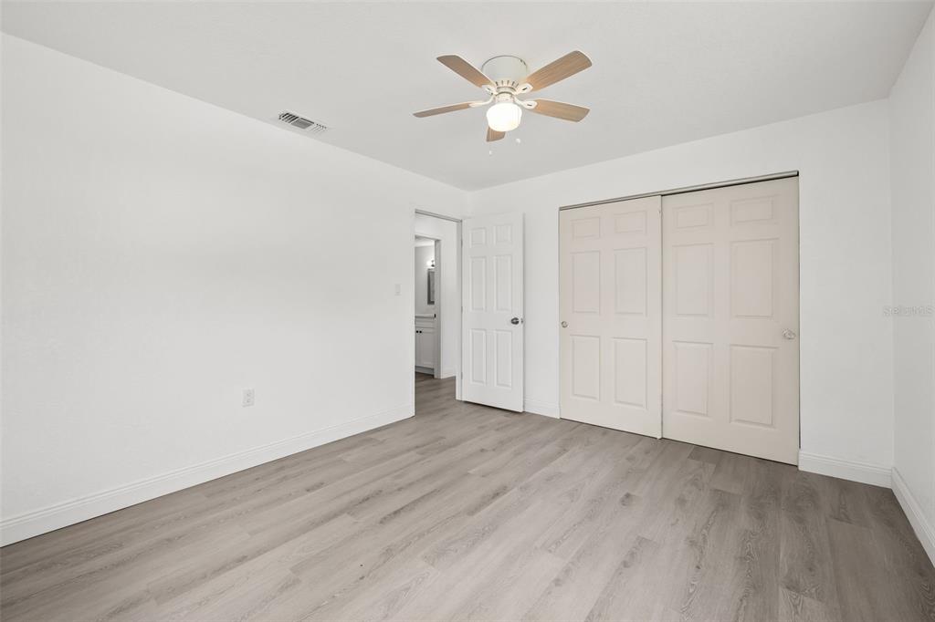 8046 Norwich Drive Port Richey, FL 34668 - Photo 20 of 31 an empty room with wooden floor and ceiling fan