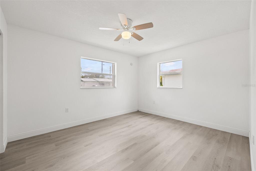 8046 Norwich Drive Port Richey, FL 34668 - Photo 21 of 31 an empty room with wooden floor and windows