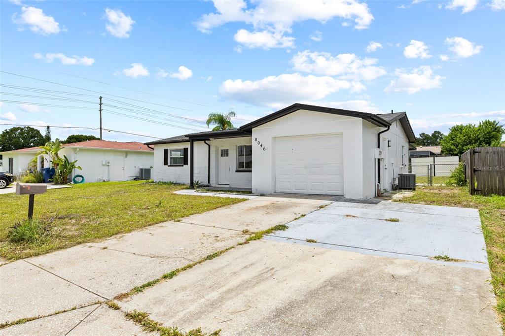 8046 Norwich Drive Port Richey, FL 34668 - Photo 3 of 31 a view of a house with a yard and garage