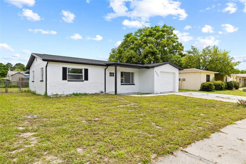 8046 Norwich Drive Port Richey, FL 34668 - Photo 4 of 31 a view of a backyard with plants and large tree