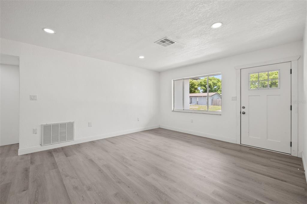 8046 Norwich Drive Port Richey, FL 34668 - Photo 8 of 31 an empty room with wooden floor and windows