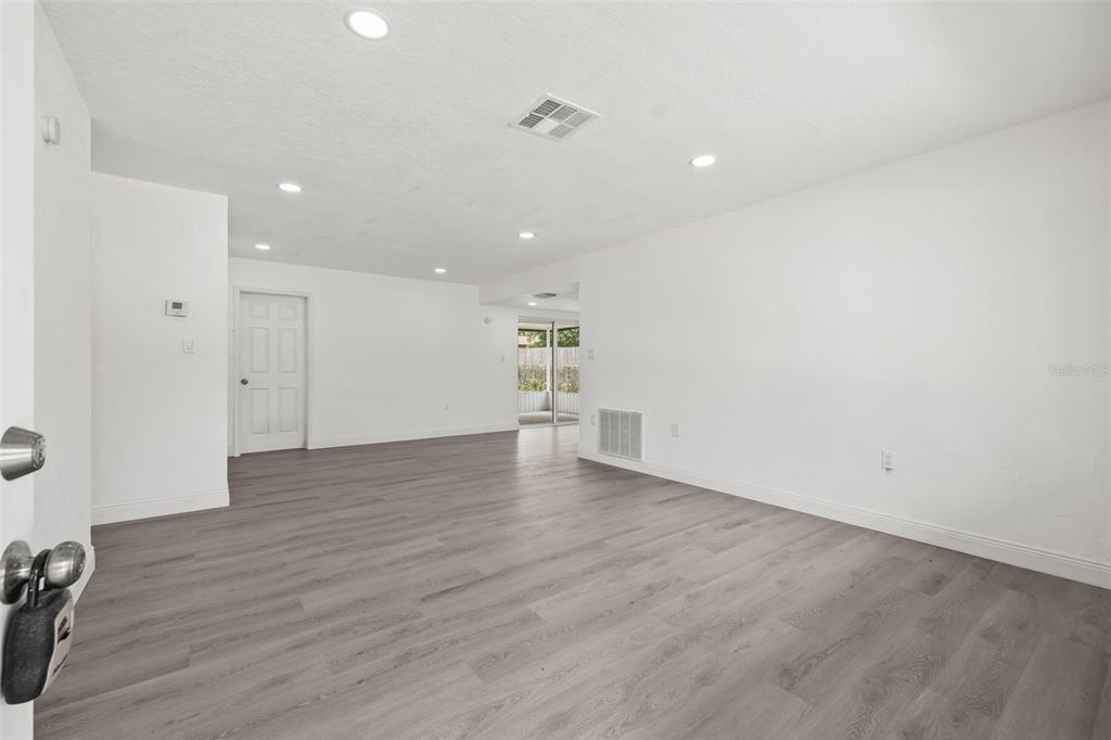 8046 Norwich Drive Port Richey, FL 34668 - Photo 9 of 31 an empty room with wooden floor and windows
