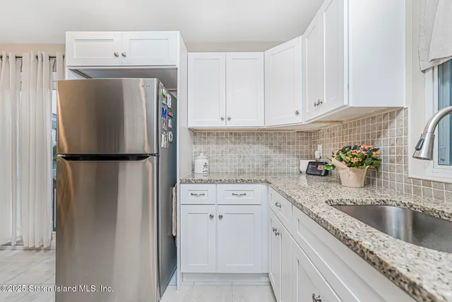 a kitchen with a refrigerator sink and cabinets