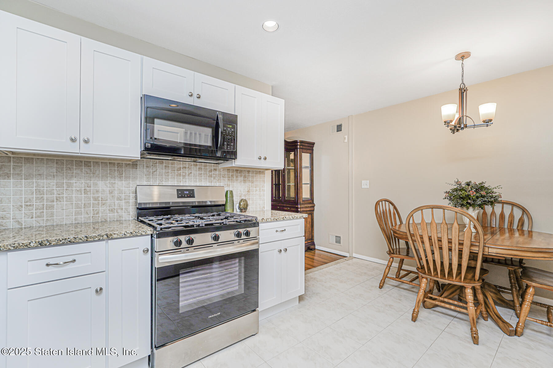 342 Chelsea Street Staten Island, NY 10307 - Photo 12 of 35 a kitchen with stainless steel appliances granite countertop a stove a sink dishwasher a refrigerator with a dining table and chairs