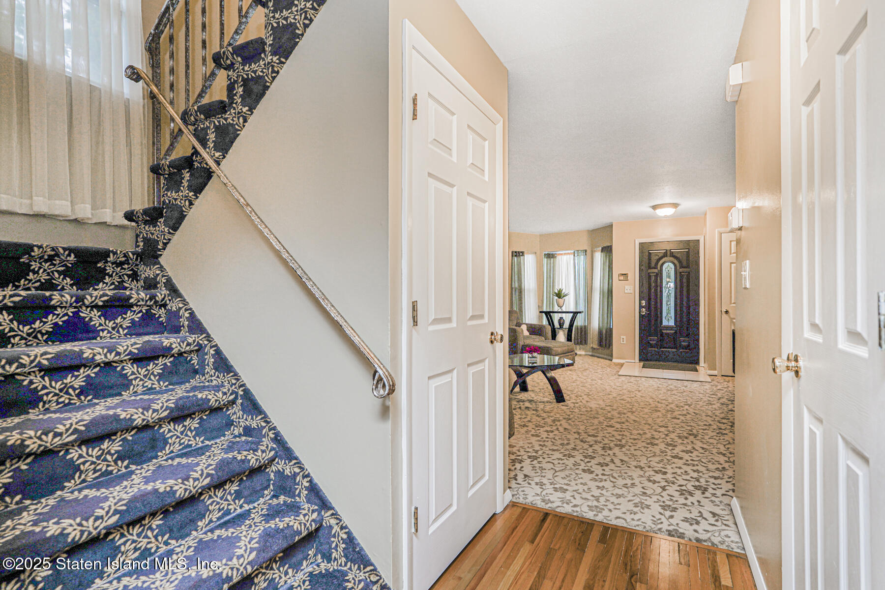 342 Chelsea Street Staten Island, NY 10307 - Photo 6 of 35 a view of a hallway to a livingroom with wooden floor and stairs