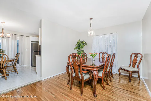 a dining room with furniture a chandelier and wooden floor
