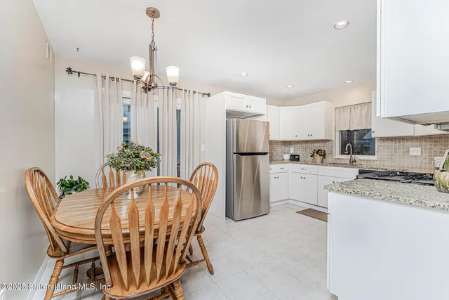 a dining room with furniture a chandelier and kitchen view