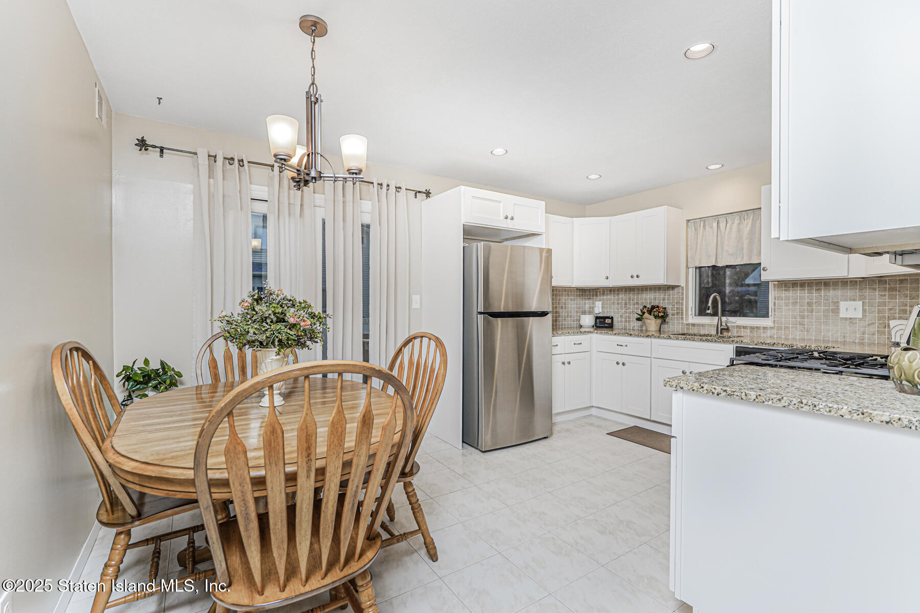 342 Chelsea Street Staten Island, NY 10307 - Photo 9 of 35 a dining room with furniture a chandelier and kitchen view