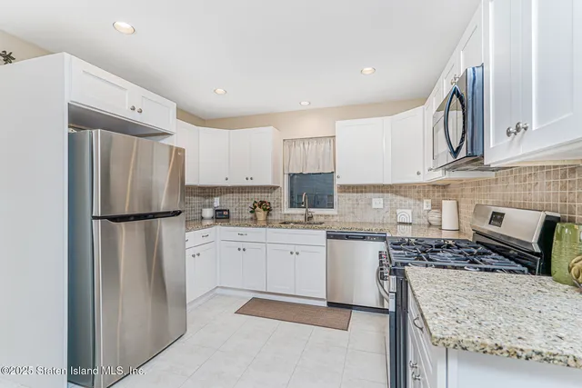 a kitchen with a refrigerator and a stove top oven
