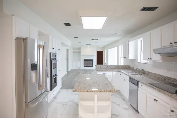a kitchen with stainless steel appliances granite countertop a refrigerator and a sink