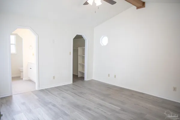 an empty room with wooden floor and mirror
