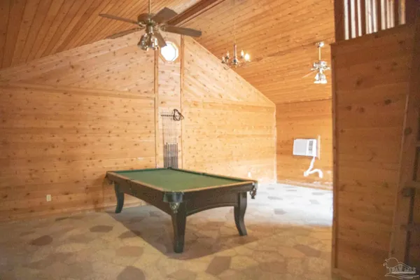 a room with pool table and windows