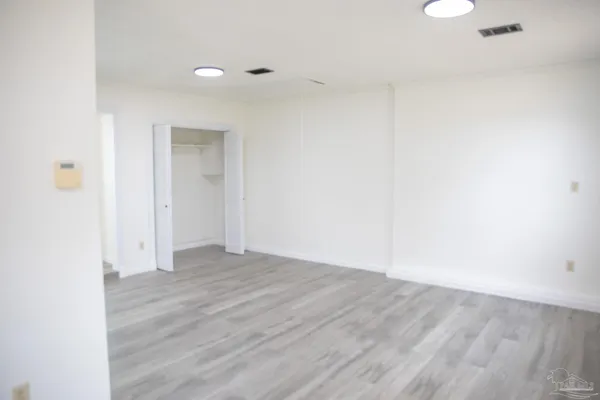 a view of an empty room with wooden floor